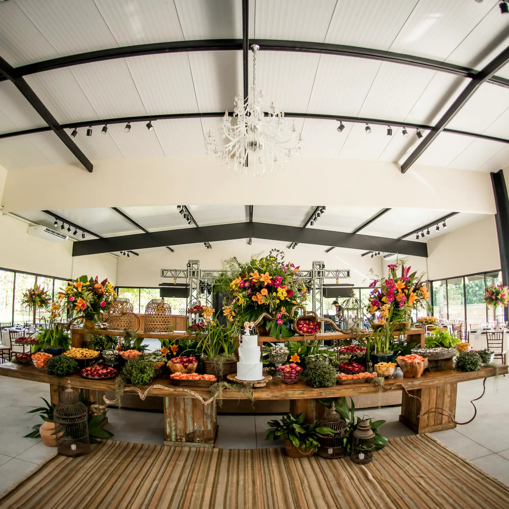 Mesa sob pergolado com uvas.