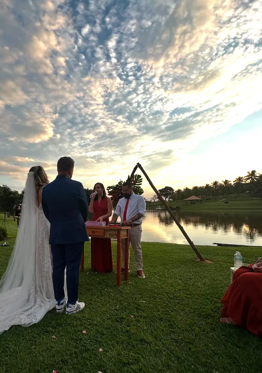 Noivos de mãos dadas durante o pôr do sol.